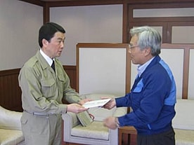President Nakakura (right) presents the check to  Miyagi Governor Murai (left)